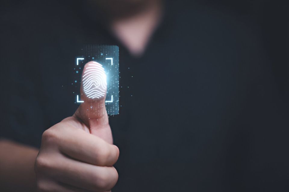 Close-up of a thumb being scanned with a glowing digital fingerprint pattern for biometric authentication.